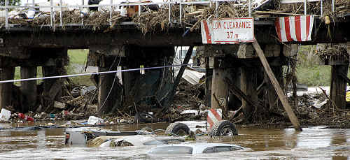 COMMUNITY DEVASTATION: Cars and debris stack up against the railway bridge in Grantham on January 12, two days after the flood. COMMUNITY DEVASTATION: Cars and debris stack up against the railway bridge in Grantham on January 12, two days after the flood.